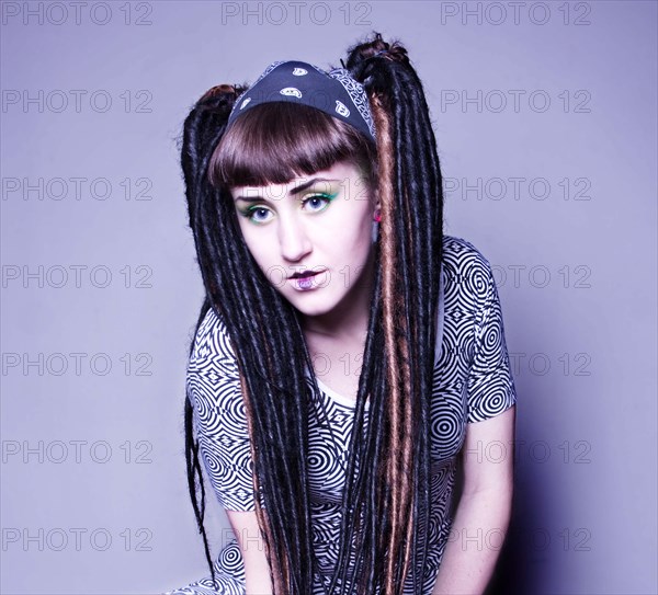 Stylish woman with makeup and dyed dreadlocks