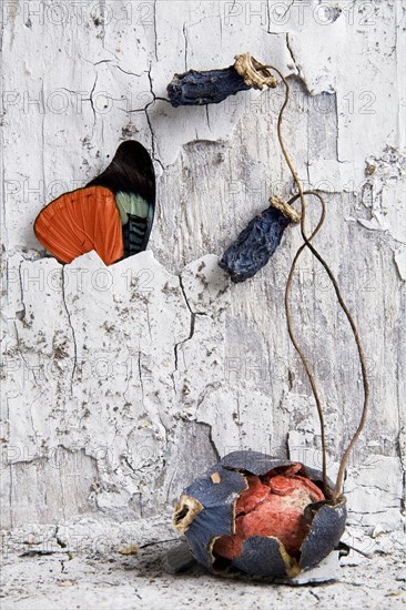 Egg in cracked shell under dilapidated wall and butterfly