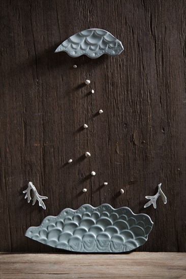 Broken ceramic pottery falling on wooden wall