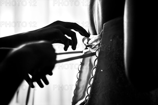 Close up of hands lacing corset