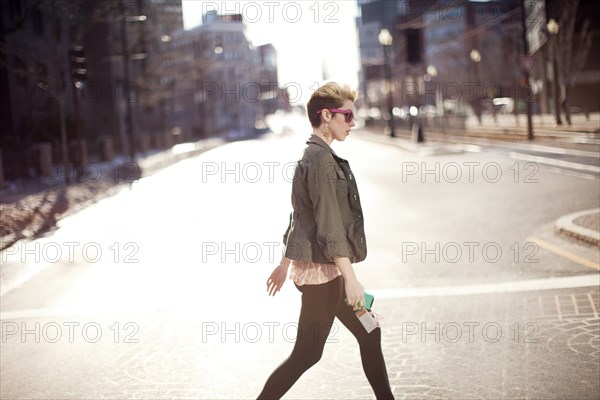 Woman walking in city intersection