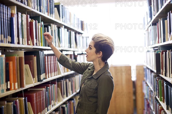 Woman searching for book in library