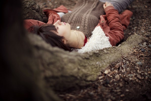 Caucasian woman laying under tree