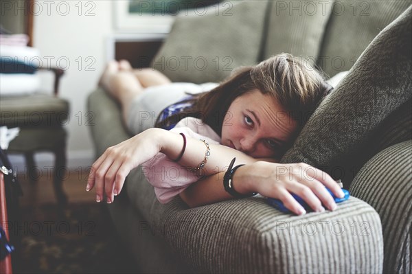 Close up of girl laying on sofa in living room
