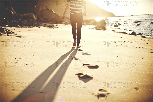 Caucasian teenage girl walking on beach