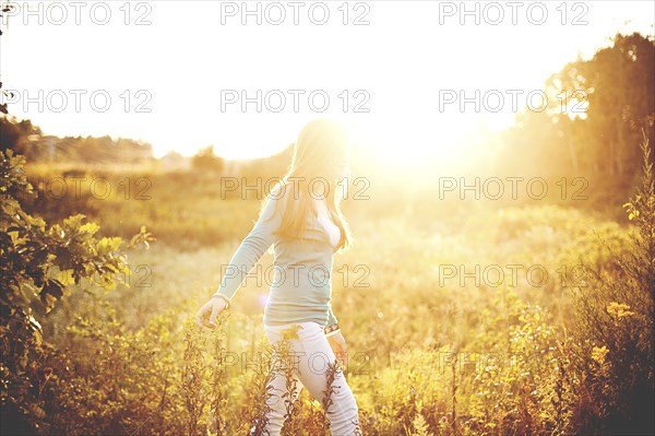 Woman walking in sunny field
