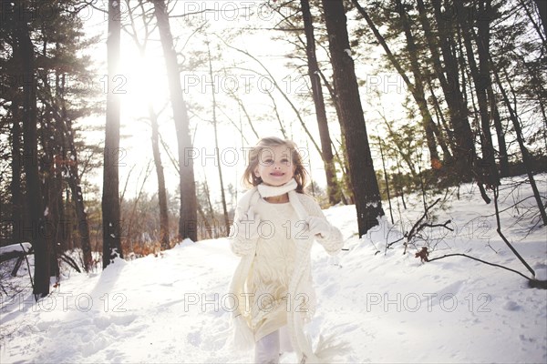 Caucasian girl running in snowy forest