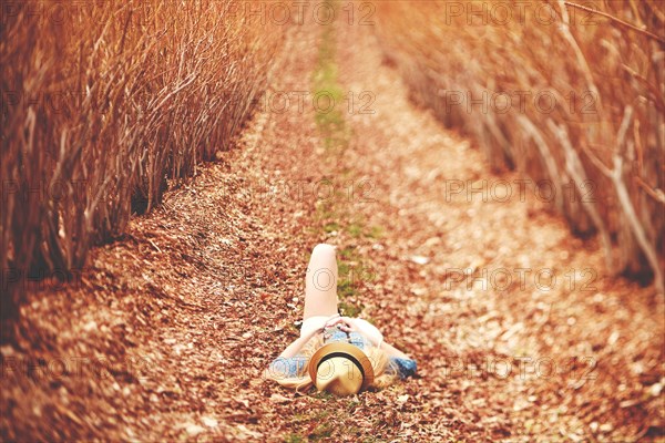 Caucasian woman laying on dirt path