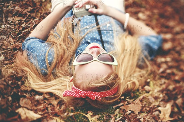 Caucasian woman laying in autumn leaves