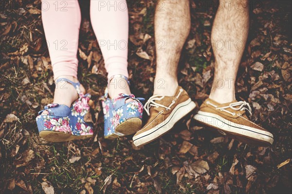 Close up of shoes of couple laying in autumn leaves