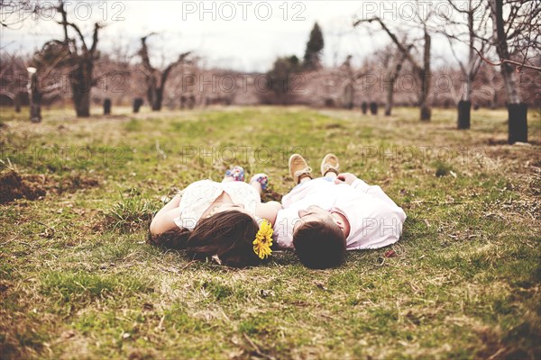 Couple laying on dirt path in vineyard