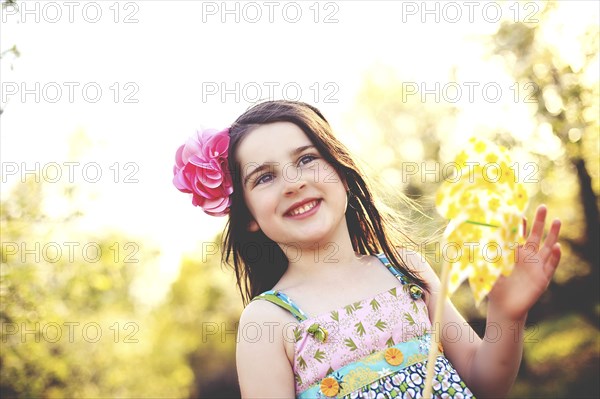 Low angle view of girl playing with pinwheel in field