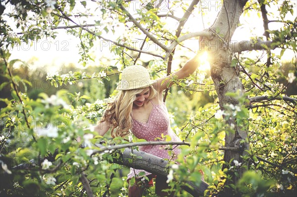 Woman climbing flowering tree