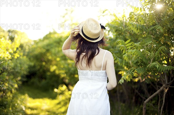 Caucasian woman holding hat on rural path