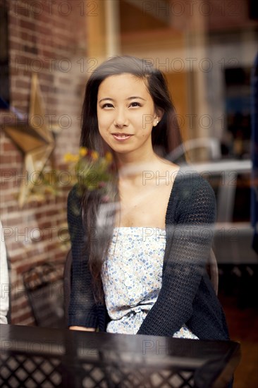 Woman smiling behind window in cafe