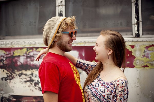 Couple hugging near dilapidated bus