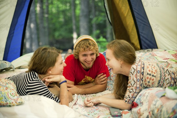 Friends relaxing in camping tent