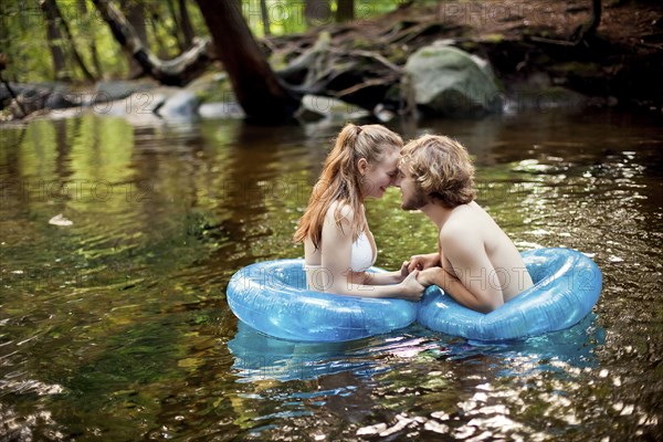 Couple holding hands in forest river