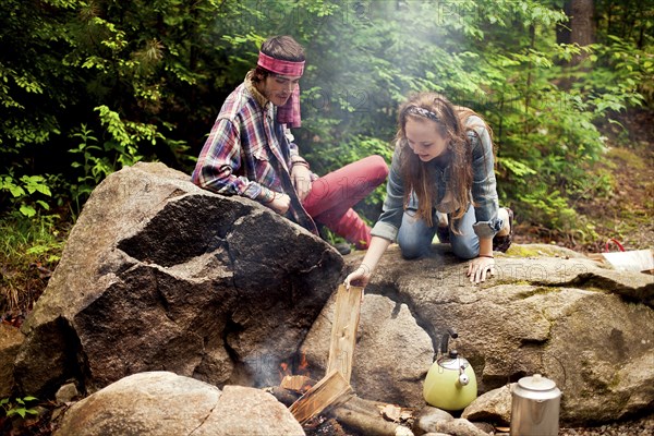 Couple building campfire in forest