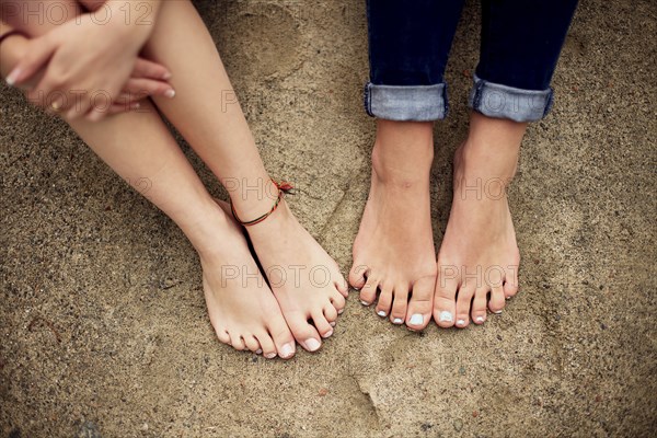 Close up of barefoot girls on rock