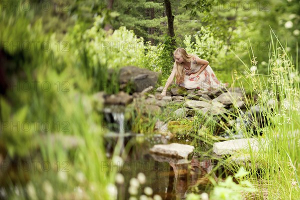 Woman exploring rural pond