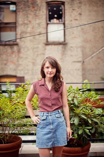 Teenage girl standing on urban rooftop