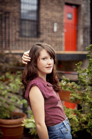 Teenage girl standing on urban rooftop