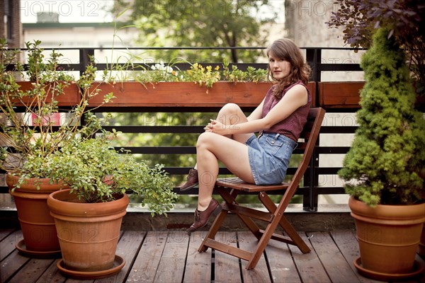 Teenage girl sitting on urban rooftop