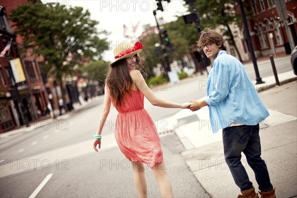 Rear view of couple walking on city sidewalk