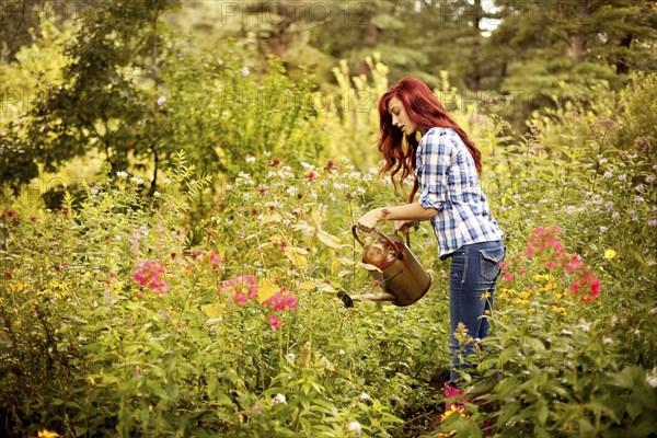 Gardener watering plants in backyard