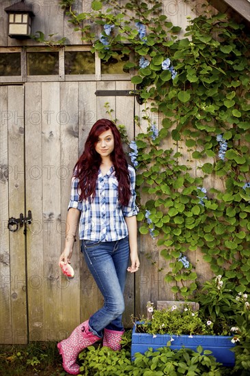 Gardener standing near wooden shed in backyard