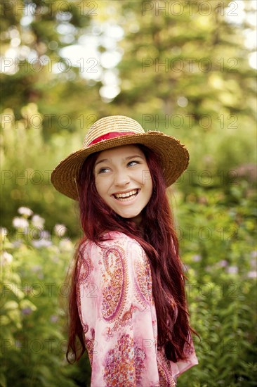 Girl wearing straw hat in garden