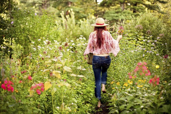 Girl wearing straw hat in garden