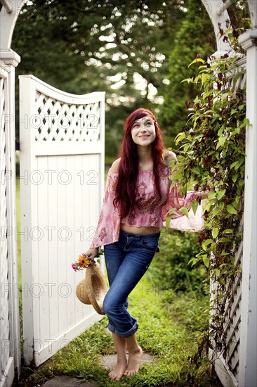 Girl carrying straw hat in garden