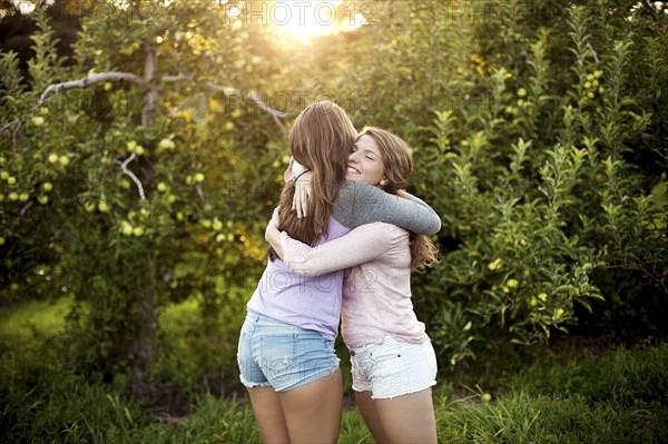 Caucasian women hugging in rural field