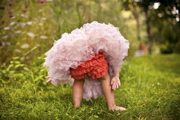 Girl wearing frilly dress in garden