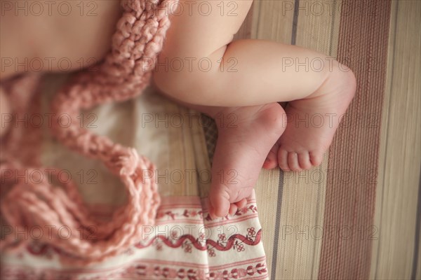 Close up of baby girl laying on knitted blanket