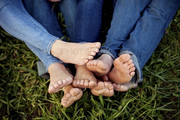 Close up of feet of friends in grass