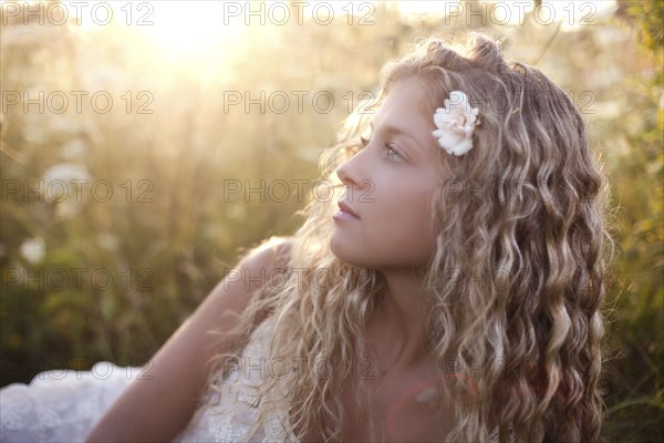 Close up of woman wearing flower in her hair in grass