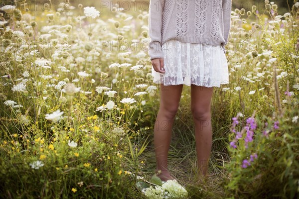 Woman standing in tall flowers