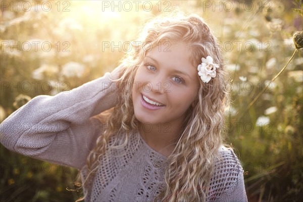 Woman sitting in tall flowers