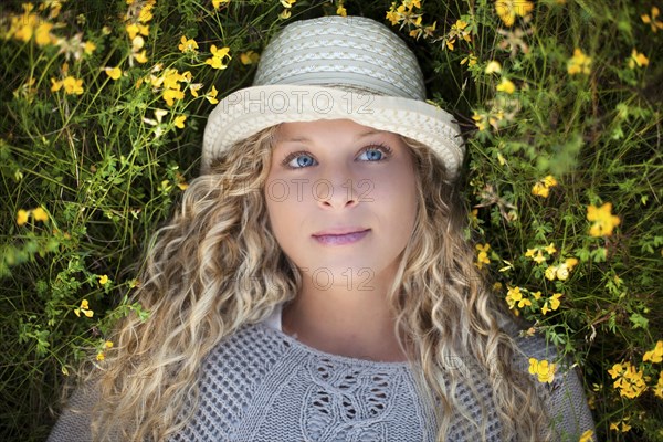 Woman in straw hat laying in flowers