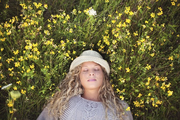 Woman in straw hat laying in flowers