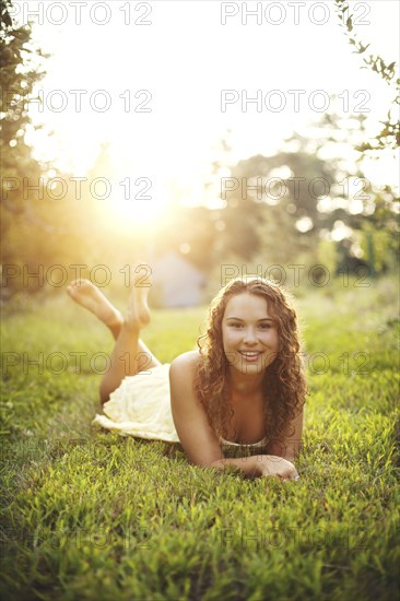 Smiling woman laying in rural field