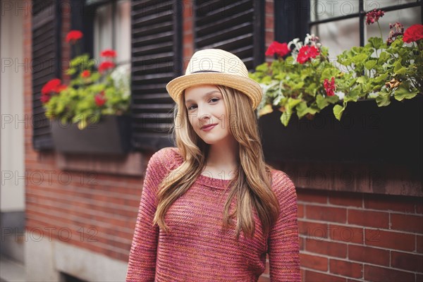 Smiling girl standing outside house