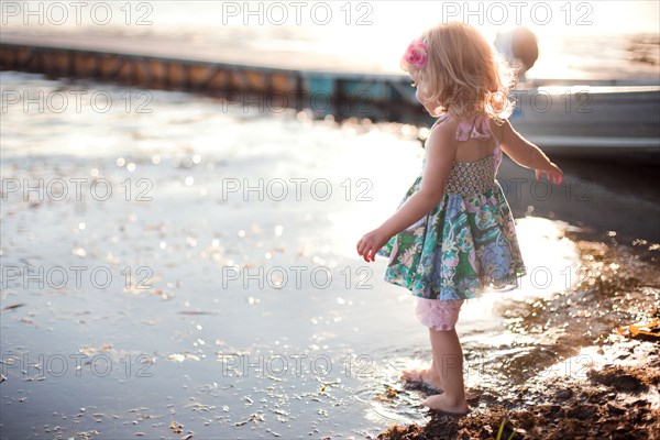 Girl dipping toe in rural lake