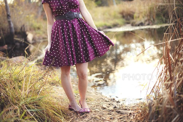 Woman standing near rural pond