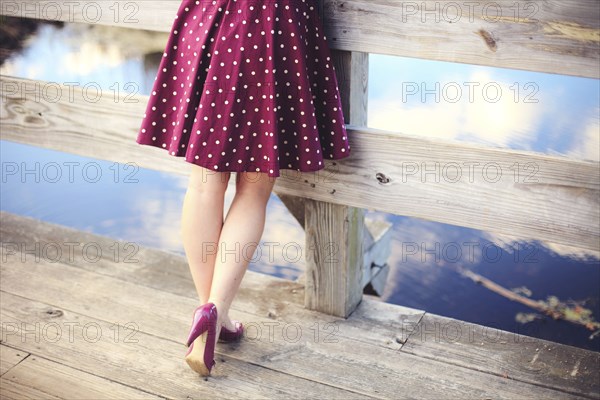 Woman standing on wooden dock over still lake