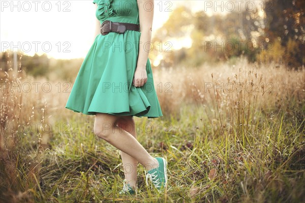 Woman standing in tall grass in rural field