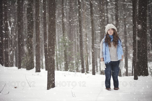 Girl standing in snowy forest